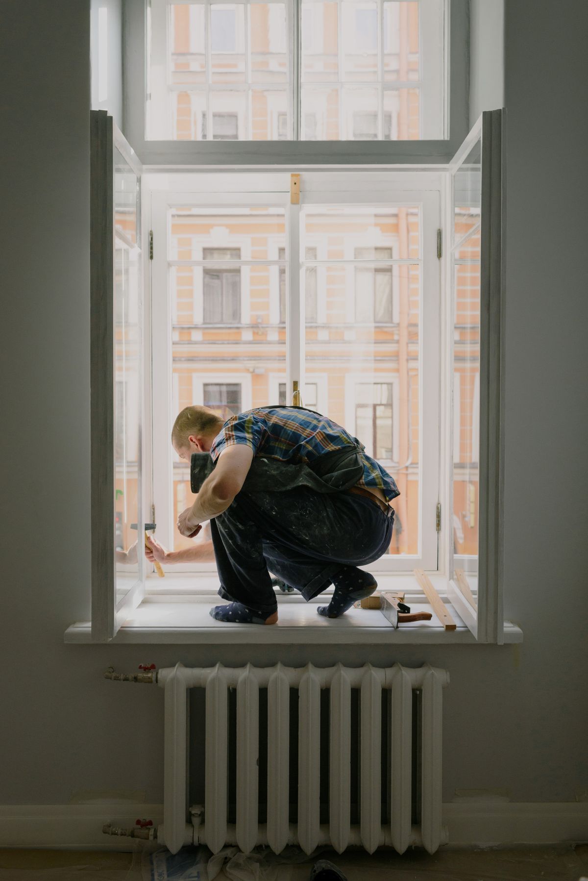 A professional repairing a window frame